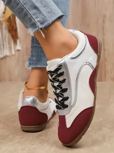 Detail shot of stylish color-block women's GAT sneakers with white and burgundy tones