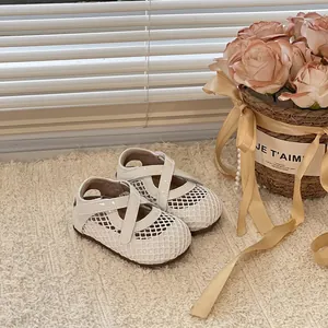 Vue détaillée de chaussures de princesse blanches évidées pour petites filles.
