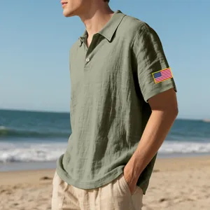 Detail van een heren linnen poloshirt in saliegroen met Amerikaanse vlag borduursel.