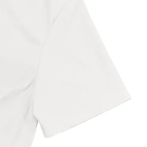 Gros plan sur la texture du tissu gaufré blanc d'un t-shirt à manches courtes pour homme.