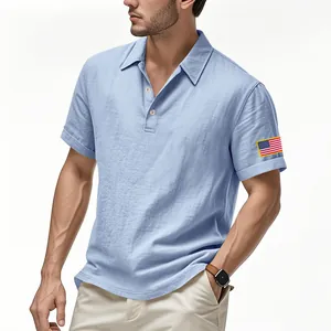 Detail van lichtblauw linnen poloshirt voor heren met Amerikaanse vlag borduursel.
