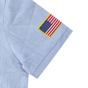 Gedetailleerde weergave van een lichtblauwe linnen poloshirt mouw met geborduurde vlag