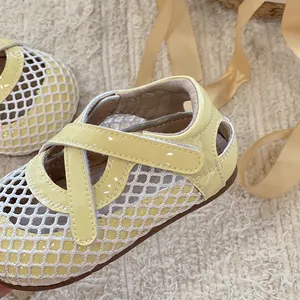 Détail en gros plan de sandales princesse en maille jaune avec lanières vernies