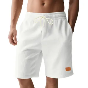 Detailweergave van witte corduroy herenshorts met trekkoord en sportief ontwerp.
