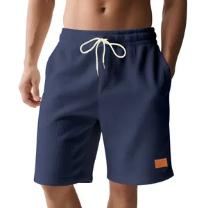 Detail van de marineblauwe corduroy herenshort met trekkoord en een kleine leren patch