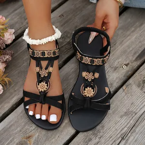 Detailansicht ethnischer schwarzer flacher Sandalen mit Holzblumen-Akzenten