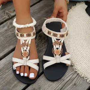 Nahaufnahme von ethnischen Boho-Sandalen mit Blumendekor und Perlenverzierung