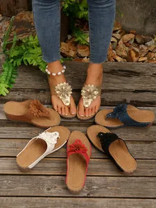 Detail view showing various colors of women's wedge sandals with decorative flowers.