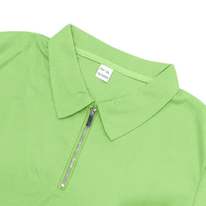 Détail en gros plan du tissu nid d'abeille et du zip d'un polo homme vert clair.