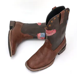 Brown leather cowboy boots with American flag embroidery and star studs on white background