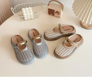 Vue détaillée des mules tressées pour enfants en argent et beige sur une table crème