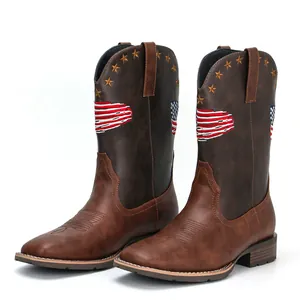 Close-up of brown square-toe cowboy boots with embroidered American flag and stars detail.