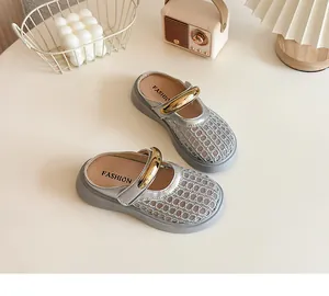 Détail des mules ajourées argentées pour enfants avec boucle dorée élégante