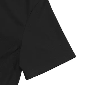 Vue détaillée de la texture gaufrée noire sur la manche d'un polo noir pour homme.
