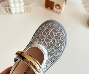Gros plan de mules tressées pour enfants avec maille respirante et boucle dorée.