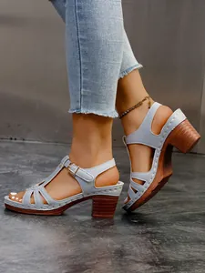 Detailansicht der hellblauen Römersandalen mit klobigem Holzabsatz und Metallschnallenriemen