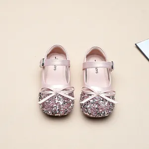 Close-up detail of pink sequined girls' Mary Jane princess shoes with an elegant bow