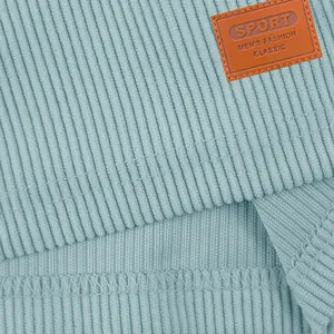 Een close-up van lichtblauwe corduroy stof textuur en zoom met een modieuze patch.