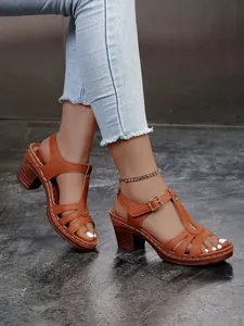 Detailansicht brauner Römersandalen mit klobigem hohem Absatz und Schnallenverschluss