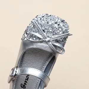 Detailed macro view of silver sequined toe and elegant bow on girls' princess dress shoe