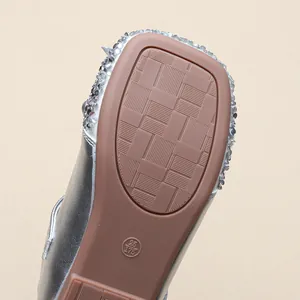 Close-up detail of non-slip rubber sole and sparkling sequins on girl's silver princess shoes
