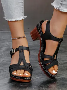 Detailansicht eleganter schwarzer Römersandalen mit klobigem Absatz und Schnalle.