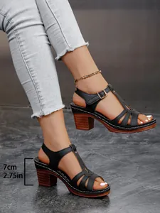 Detaillierte Seitenansicht schwarzer Römersandalen mit 7 cm Blockabsatz und Schnallen