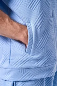 Close-up of men's light blue outdoor jacket showing jacquard texture and side pocket detail