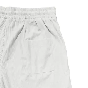 Vista dettagliata dei pantaloncini in velluto a coste bianco con elastico in vita e tasca.