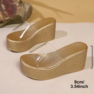 Détail montrant le talon compensé de 9 cm des sandales à plateforme dorées.