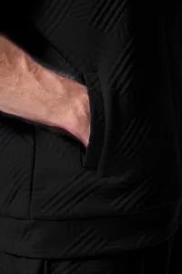 Close-up of the pocket and textured jacquard fabric of a men's black outdoor jacket