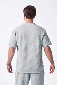 Back view of man in light blue textured jacquard polo shirt and matching casual shorts