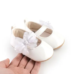 Close-up van witte prinsessen babyloopschoentjes met een detail van kant en strik