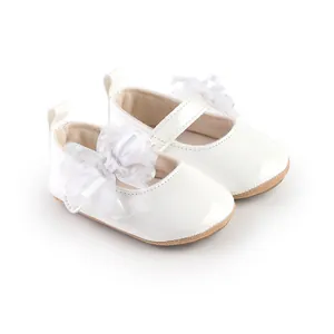 Detailopname van witte babyprinsessen-loopschoenen met een elegante kanten bloem detail.