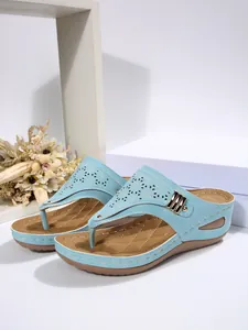 Detailed view of light blue wedge thong sandals with intricate laser-cut patterns