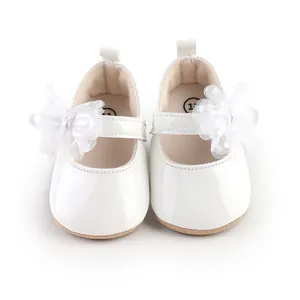 Detail van witte lakschoenen voor babyprinsessen met elegante kanten bloemdecoraties.