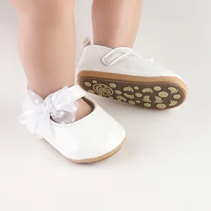 Detail van witte prinses baby wandelschoenen met kanten strik en antislip rubberen zool