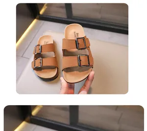 Dettaglio dei sandali per bambini in pelle scamosciata marrone con doppie fibbie