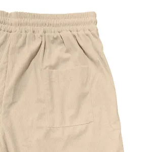Vista dettagliata dei pantaloncini in velluto a coste beige da uomo con trama del tessuto