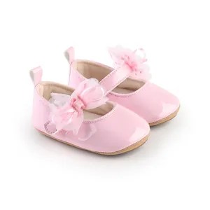 Detailopname van roze lak schoentjes voor baby meisjes met een verfijnde kanten strik