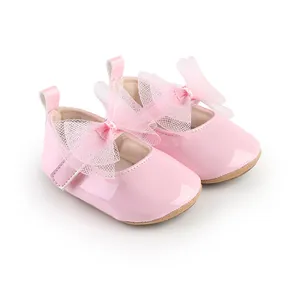 Primer plano de zapatos de princesa rosa para bebé en charol con lazo de malla suave
