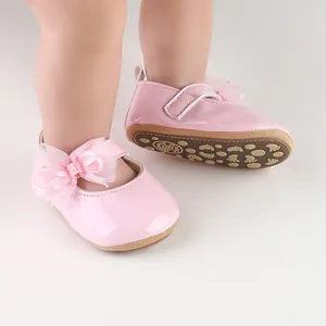 Detailopname van roze lakschoenen voor babyprinsessen met een delicate kanten strik
