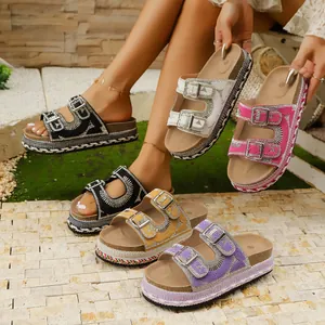 Macro view of multi-color rhinestone platform sandals with double buckle straps.