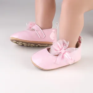 Detailopname van roze glanzende babyprinsessenschoentjes met een mesh strikdetail