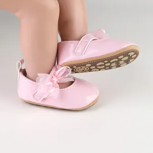 Gedetailleerde weergave van roze baby prinsessenschoenen met strik en antislipzool