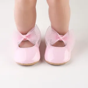Primer plano de zapatos de princesa para bebé en charol rosa con lazo de malla