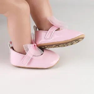 Detalle lateral de zapatos de princesa en charol rosa para bebé con lazo de malla suave