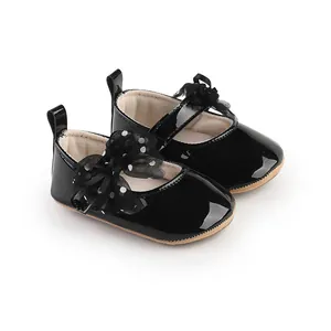 Detailoverzicht van zwarte lakschoenen voor babyprinsessen met een strik met stippen