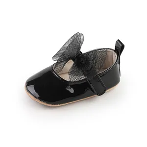 Primer plano de zapato de princesa negro para bebé con un gran lazo de malla