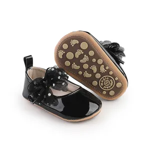 Detailweergave van zwarte lakschoenen voor babymeisjes met een gestipte strik